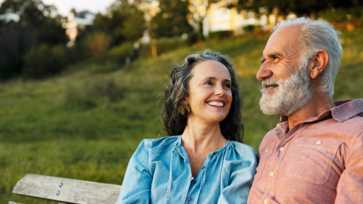 smiling couple sits outdoors
